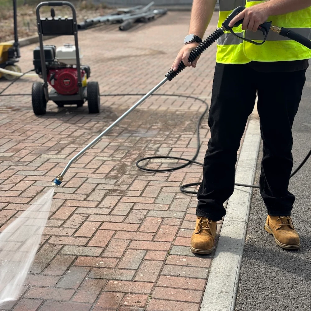 Technician pressure washing a driveway