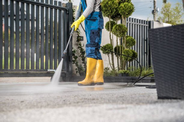 Residential concrete driveway being professionally pressure washed to remove stains and grime.