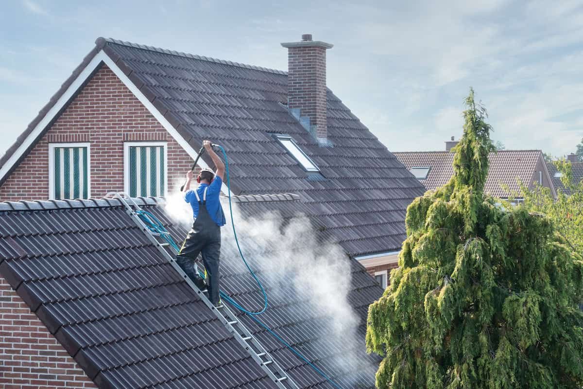 roof washing team busy soft washing a roof